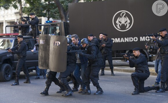 Romero (Alexandre Nero) é protegido pelo escudo policial, no primeiro capítulo da novela 'A Regra do Jogo'