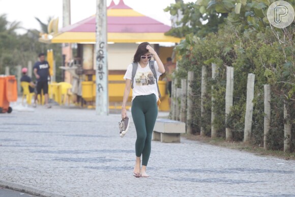 Com uma legging verde, blusa branca estampada e óculos da Chilli Beans, atriz passeia pelo Rio
