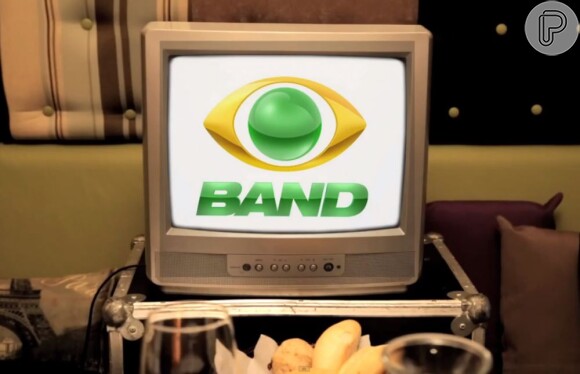 No vídeo, Rafinha parece discutir com uma mulher, mas depois aparece uma TV com a logo da Band