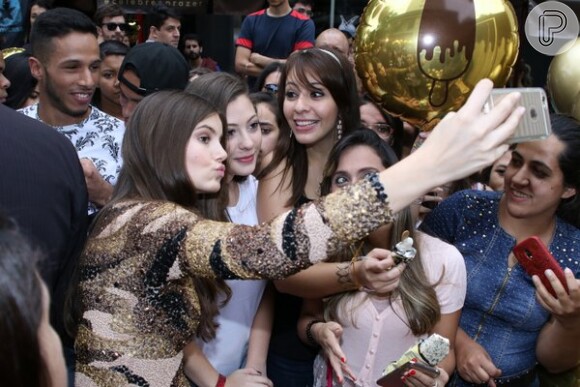No meio da multidão, Camila Queiroz atendeu aos pedidos de fotos e ela própria fez o registro no celular dos fãs