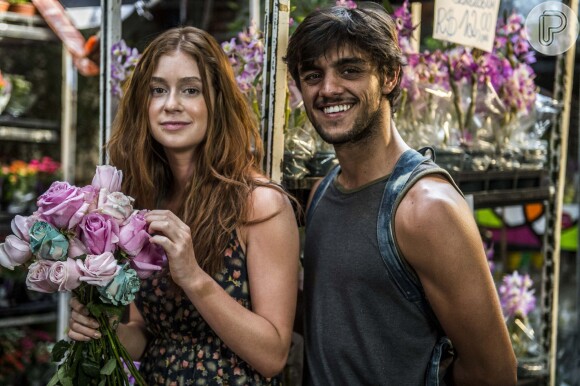 Eliza (Marina Ruy Barbosa) agradece por Jonatas (Felipe Simas) ensiná-la a vender flores, ele não resiste e acaba beijando-a, na novela 'Além do Tempo'