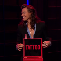 Harry Styles, do One Direction, tatua nome de programa no braço, ao vivo. Foto!