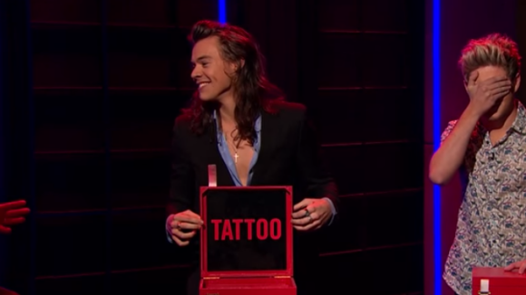Harry Styles, do One Direction, tatua nome de programa no braço, ao vivo. Foto!