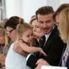 David Beckham segura a filha, Harper Seven, na primeira fileira do desfile de sua mulher, Victoria Beckham