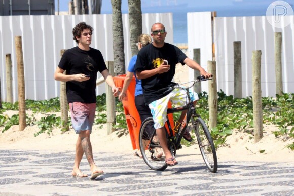 Felipe Dylon no calçadão da praia de Ipanema com um amigo