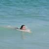 Giovanna Antonelli se jogou no mar de roupa depois de praticar exercícios debaixo de sol na praia da Barra da Tijuca