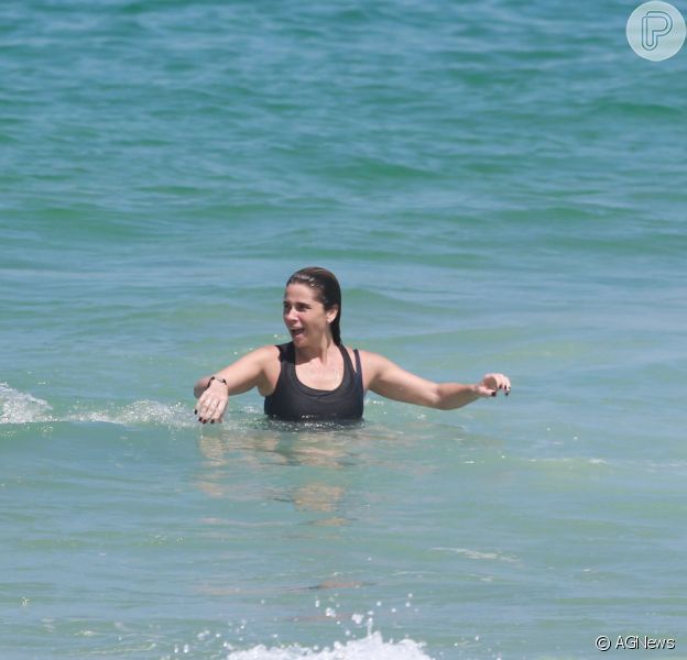 Giovanna Antonelli se jogou no mar de roupa depois de praticar exercícios debaixo de sol na praia da Barra da Tijuca