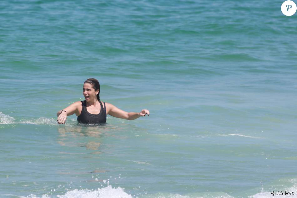 Giovanna Antonelli se jogou no mar de roupa depois de praticar exercícios debaixo de sol na praia da Barra da Tijuca