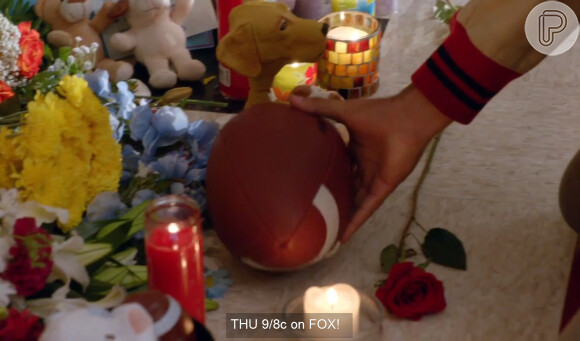 Blaine (Darren Criss) coloca uma bola de futebol americano, o esporte que Finn Hudson (Cory Monteith) praticava em 'Glee' no memorial que foi montado para o personagem