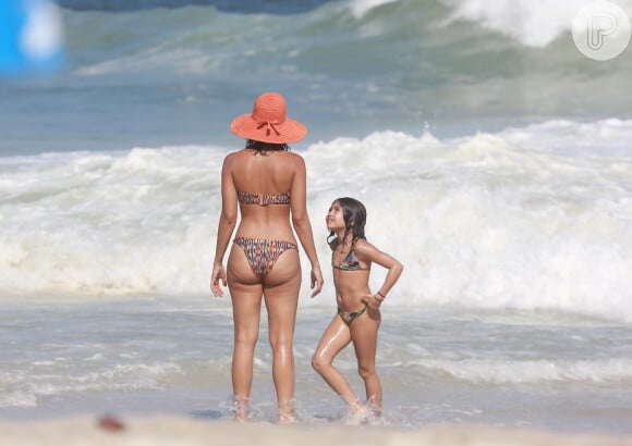 Com a filha, Antonia, Camila Pitanga brincou na beira do mar enquanto se refrescava do calor