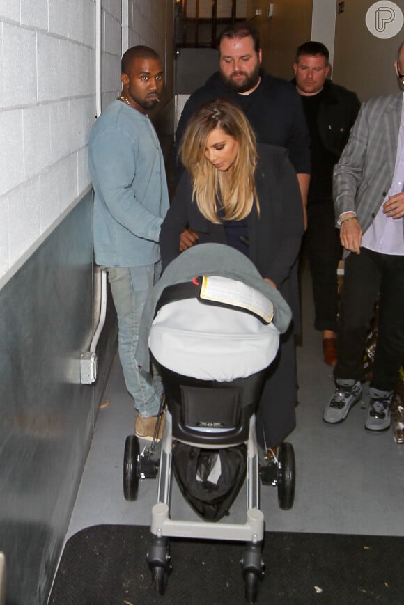 Kim Kardashian e Kanye West saem para jantar com a pequena North no carrinho acompanhados de seguranças