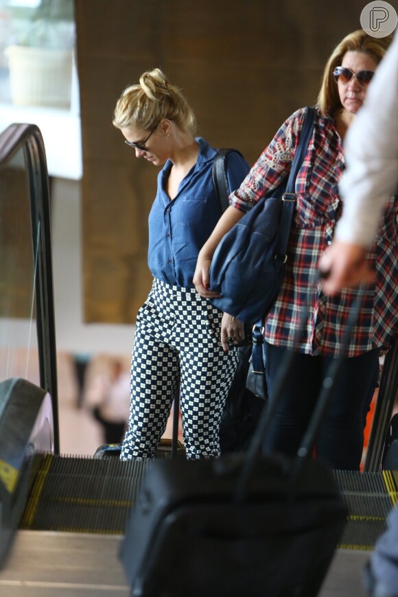 Carolina Dieckmann carrega sua mala no aeroporto