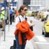 Paolla Oliveira carrega seu casaco laranja ao desembarcar em aeroporto do Rio