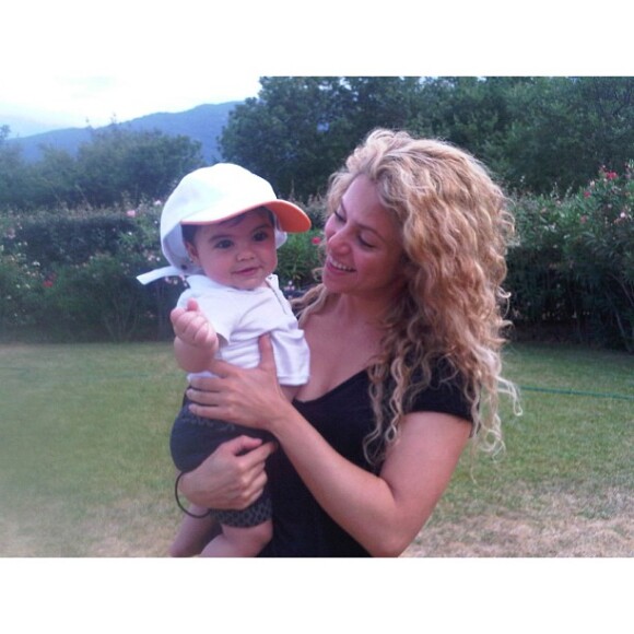 Shakira e o pequeno Milan em seu colo, em um bosque francês