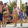 Danielle Winits e o namorado, André Gonçalves, passearam no calçadão da praia da Barra da Tijuca, com os filhos da atriz