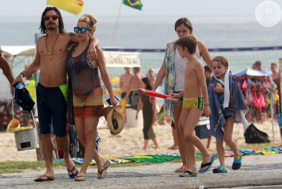 Danielle Winits e o namorado, André Gonçalves, passearam no calçadão da praia da Barra da Tijuca, com os filhos da atriz, Noah e Guy