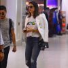 Alessandra Ambrosio passou por aeroporto usando calça pantacourt rasgada com camisa estampada e alpargata. Para dar elegância ao look, ela escolher blazer branco com detalhes dourados e bolsa Chanel