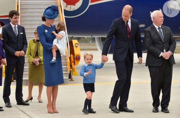 Príncipe George acena para os fotógrafos ao deixar avião