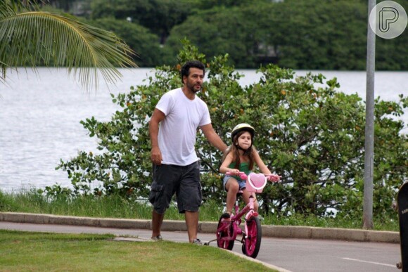 Ainda aprendendo a pedalar, Julia foi orientada por Marcos Palmeira, que segurou a bicicleta para a filha