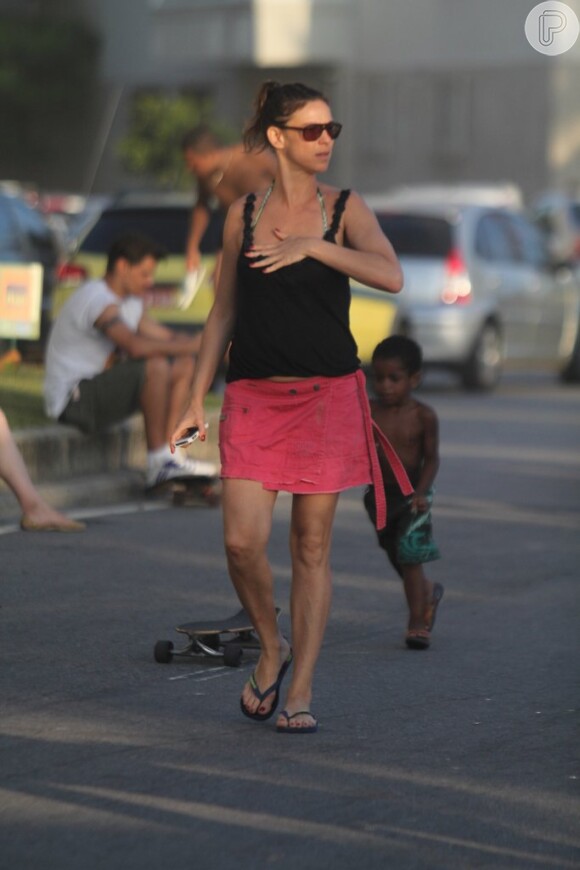 Maria Paula caminha pela orla da praia de Ipanema sem a companhia do moreno