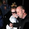 Adele esconde rosto do filho durante desembarque no aeroporto de Los Angeles, nos Estados Unidos, onde chegou para a festa da premiação do Globo de Ouro, em 11 de janeiro de 2013