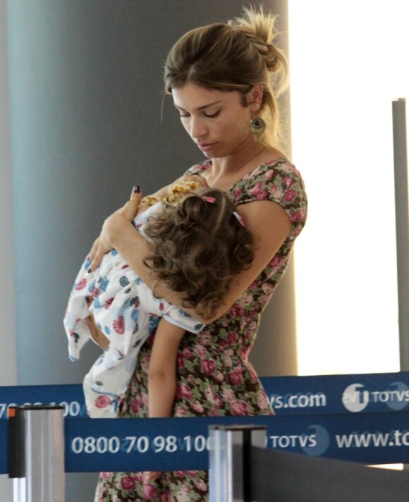 Grazi Massafera embarca com sua filha, Sofia, de 1 ano e 9 meses, dormindo em seu colo