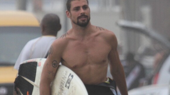 Em dia de surfe, Cauã Reymond exibe corpo tatuado e posa sorridente com fãs