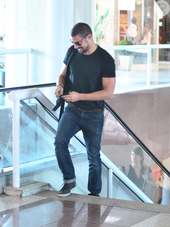 Cauã Reymond embarca de blusa preta e calça jeans