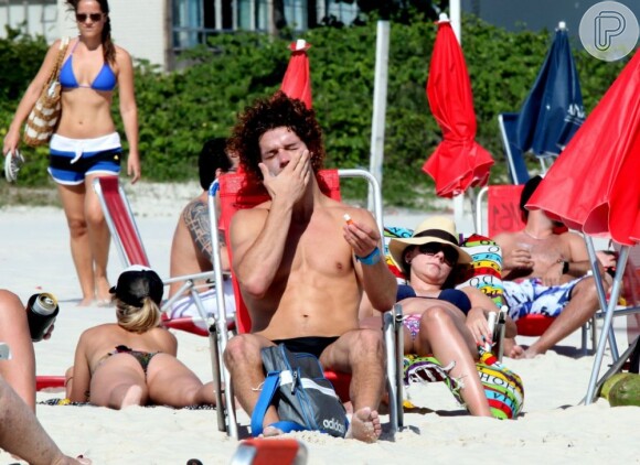 José Loreto passa protetor solar em seu rosto na praia da Barra, no Rio de Janeiro