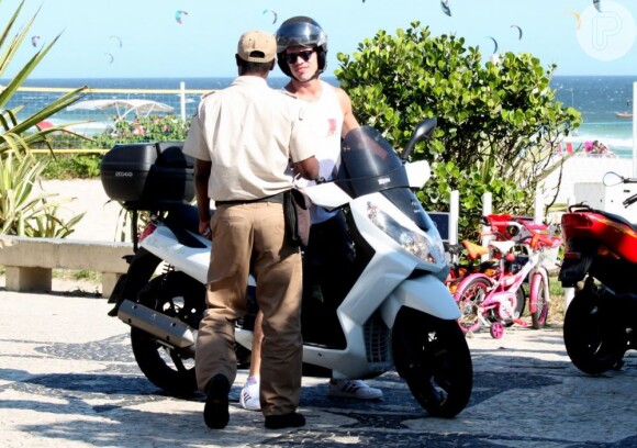 José Loreto conversa com um dos quatro guardas que o mandaram tirar sua moto do local proibido em que estava estacionada