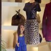 Suri Cruise flagrada em momento de encantamento com roupas de adulto em uma loja feminina