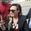 Demi Lovato mostra seu sidecut ao distribuir autógrafos para fãs no Rio de Janeiro