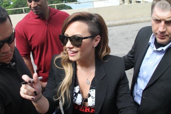 Demi Lovato mostra seu sidecut ao distribuir autógrafos para fãs no Rio de Janeiro