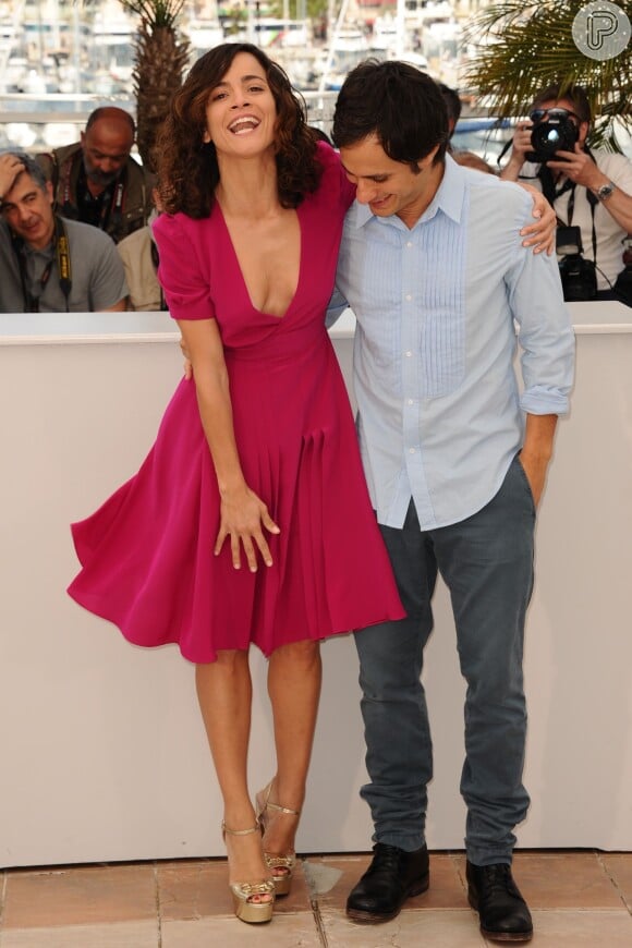 Alice Braga cai na gargalhada ao segurar o vestido durante o Festival de Cannes 2014