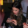 Bruna Marquezine mexe no celular durante o jantar