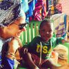 Adriane Galisteu posa sorridente ao lado de bebê durante viagem para Angola