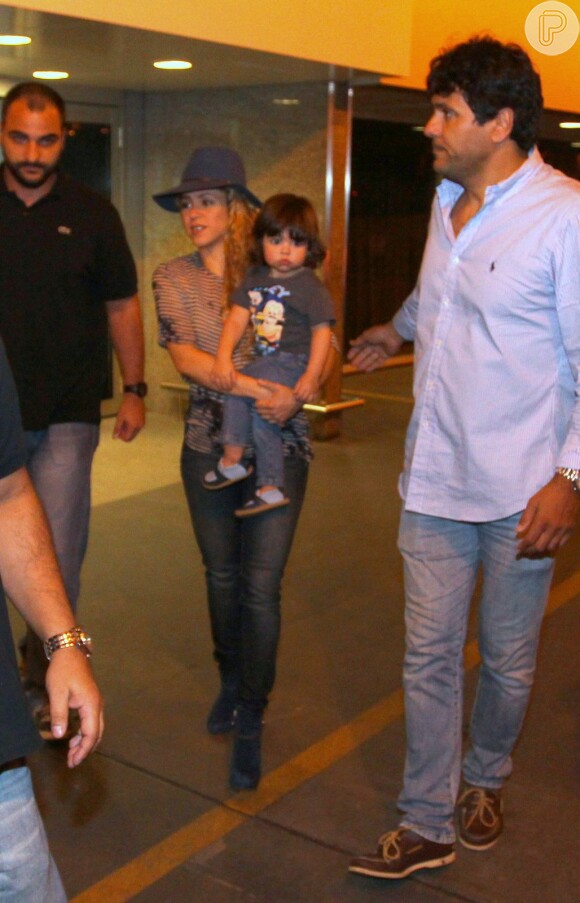 Shakira escolheu um look estiloso para desembarcar: blusa soltinha listrada, botas de camurça azuis, chapéu de feltro da mesma cor, e calça jeans