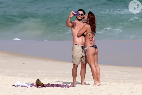 Yanna Lavigne e Bruno Gissoni não desgrudaram do celular na areia da praia