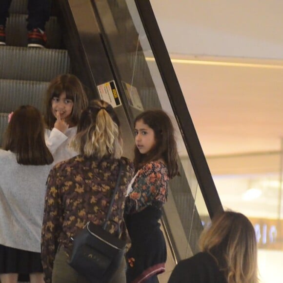 Giovanna Antonelli conversa com as filhas gêmeas, Antonia e Sofia, ao subir escada rolante no Rio