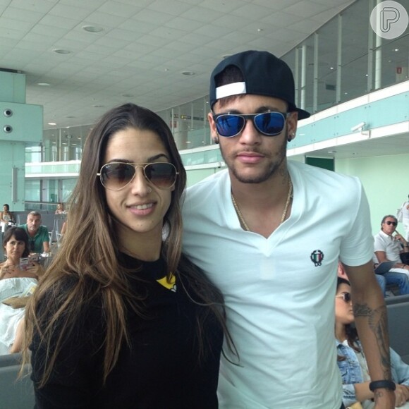 Uma fã posa ao lado de Neymar no aeroporto de Barcelona momentos antes de seguirem no mesmo voo para Ibiza. Na imagem a atriz Bruna Marquezine aparece ao fundo