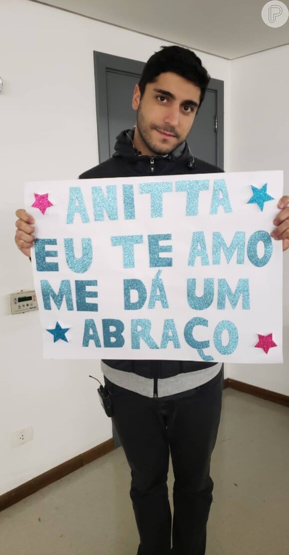 Thiago Magalhães, marido de Anitta, segurou uma placa escrito 'Anitta, eu te amo. Me dá um abraço'