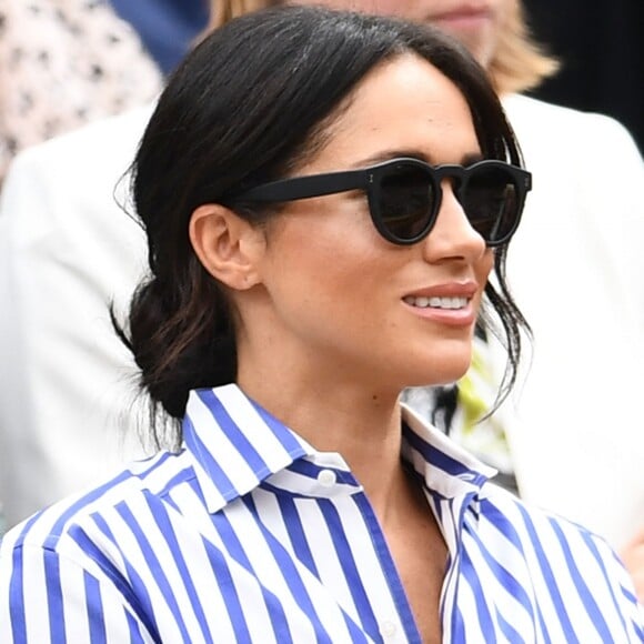 Com o penteado coque baixo, que já virou sua marca registrada, Meghan Markle usa acessórios como óculos de sol