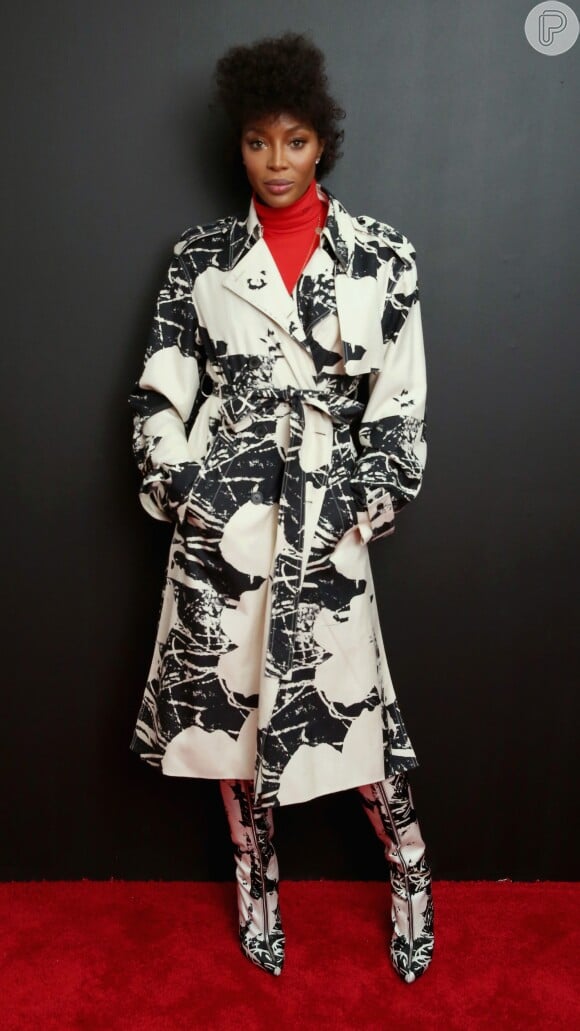 Ousada, Naomi Campbell combinou a estampa do trench coat e da bota para ir ao desfile da Calvin Klein