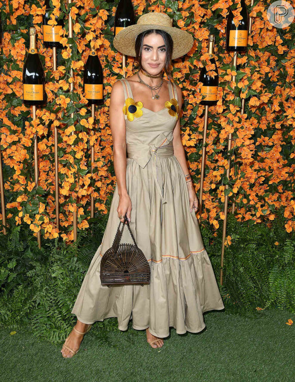 Detalhe floral: a blogueira brasileira Camila Coelho escolheu um vestido longo e liso com duas flores amarelas fixadas na alça do vestido