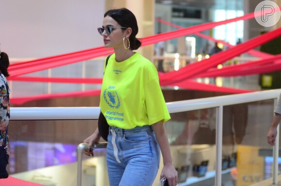Bruna Marquezine combinou uma blusa amarelo neon de uma agência humanitária com jeans e salto