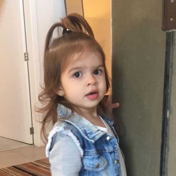Valentina, filha de Mirella Santos e Ceará, usou um colete jeans por cima de uma blusa de manga