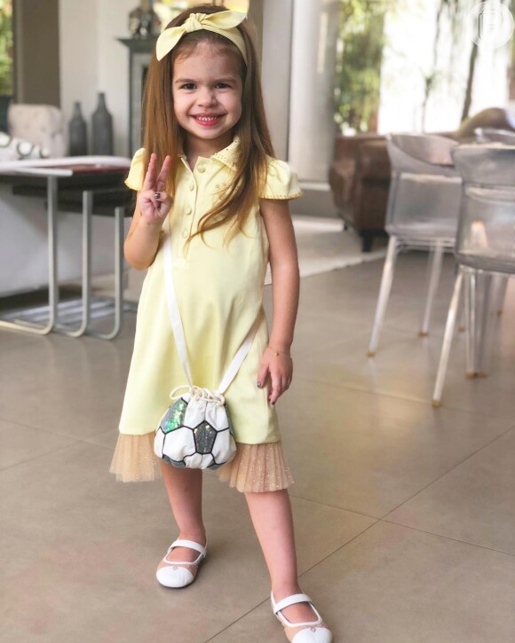 Valentina, filha de Mirella Santos e Ceará, usou vestido amarelo e laço da mesma cor no cabelo
