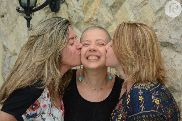 'Ao encarar a careca, estaria encarando o câncer de frente, relata Luciana, abraçada pelas irmãs Daniele e Cláudia na foto

