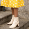 A bota branca garante um look romântico e retrô com saia midi no outono