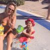 Em clique recente na piscina com a mãe, Eliana, Manuela apareceu com biquíni e touca combinando